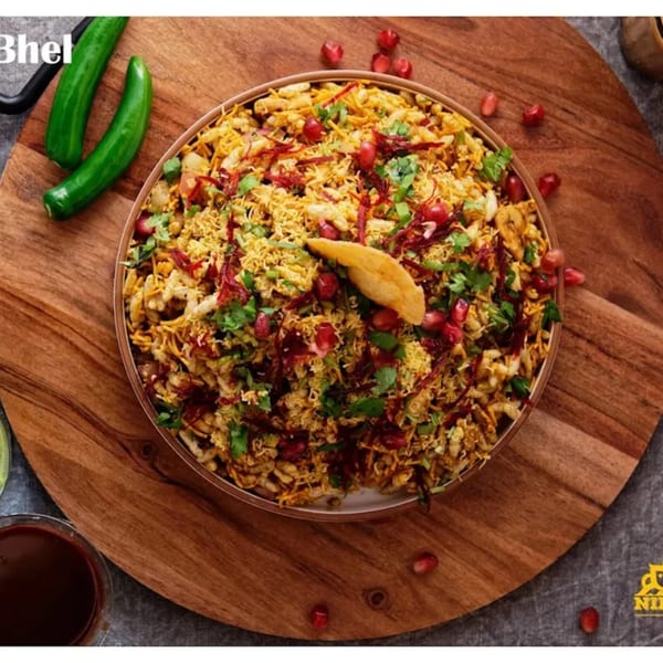 Nirmanz Food Boutique's Bhel, a vibrant Indian snack with puffed rice, chutneys, and pomegranate seeds.